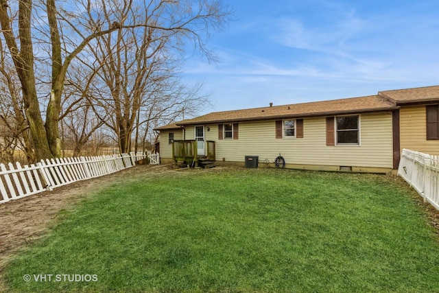 back of house with central AC and a yard