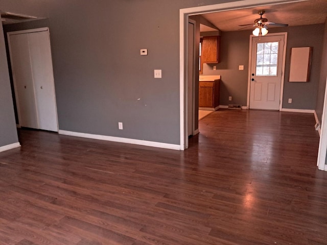 unfurnished living room featuring dark hardwood / wood-style floors and ceiling fan