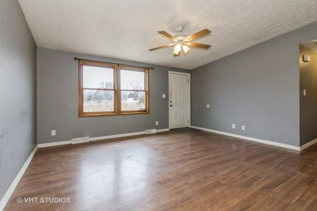 spare room with a textured ceiling, dark hardwood / wood-style floors, and ceiling fan