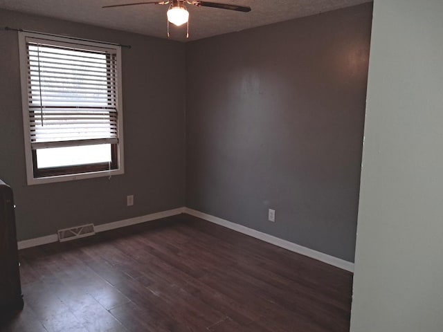 unfurnished room with ceiling fan, dark hardwood / wood-style floors, and a textured ceiling