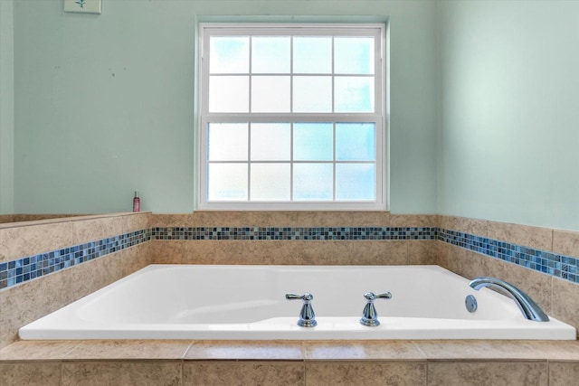 bathroom with a healthy amount of sunlight and a relaxing tiled tub