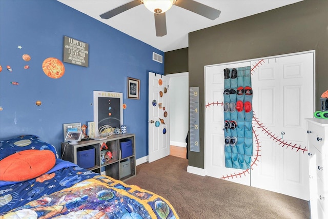 carpeted bedroom featuring ceiling fan and a closet