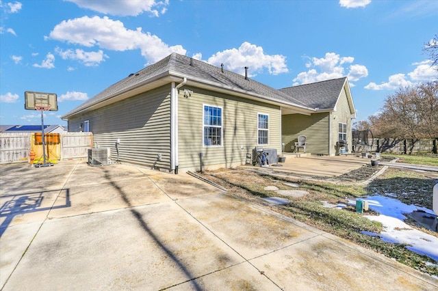 back of property with central AC and a patio area