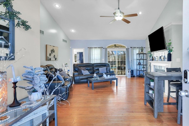 living room with ceiling fan, high vaulted ceiling, and hardwood / wood-style floors