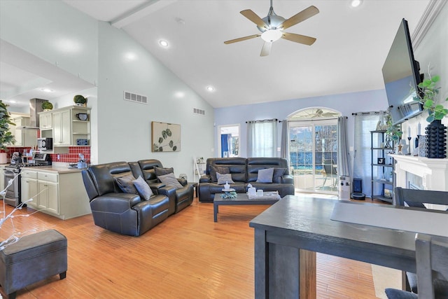 living room with beamed ceiling, ceiling fan, high vaulted ceiling, and light wood-type flooring