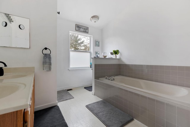 bathroom with vanity and tiled tub