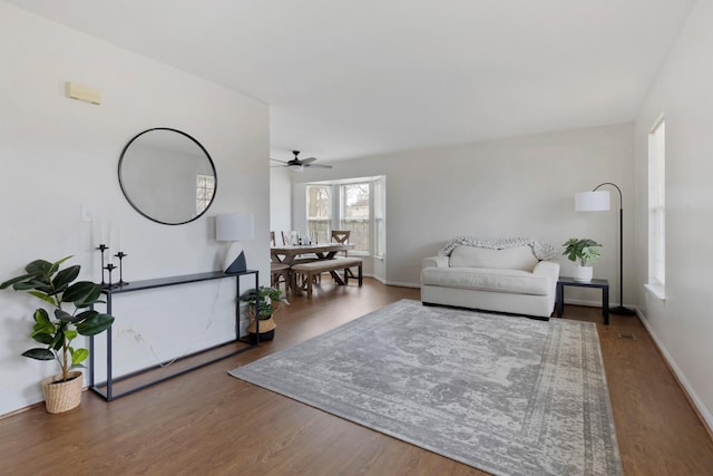 living room with dark wood-type flooring and ceiling fan