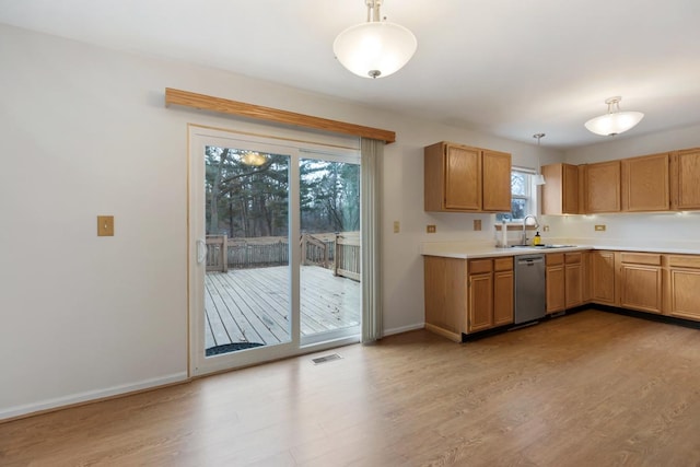 kitchen with hanging light fixtures, sink, stainless steel dishwasher, and light wood-type flooring