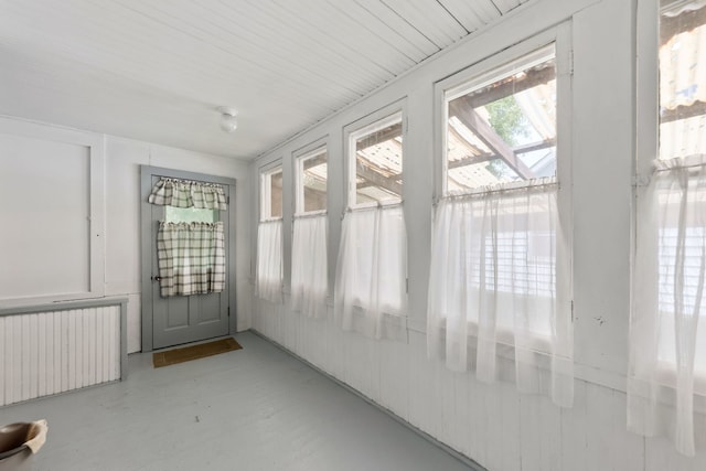 unfurnished sunroom with radiator heating unit