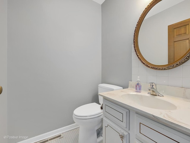 bathroom featuring tasteful backsplash, tile patterned floors, vanity, and toilet