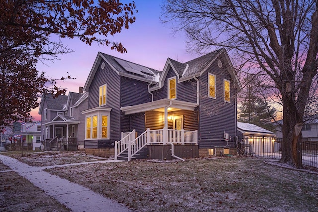 view of front of property featuring covered porch and solar panels