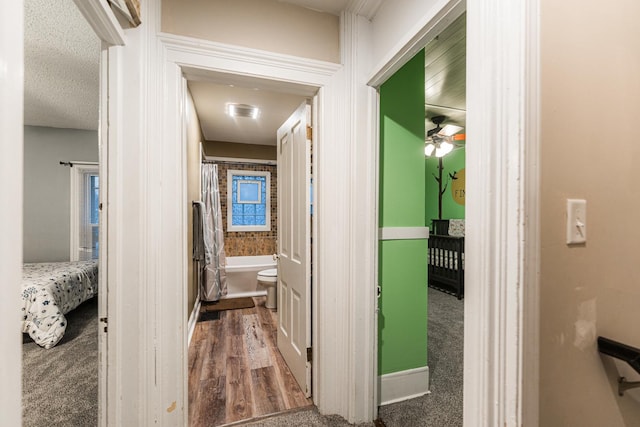 hall featuring dark wood-type flooring and a textured ceiling