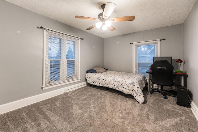 bedroom with multiple windows, carpet flooring, and a textured ceiling