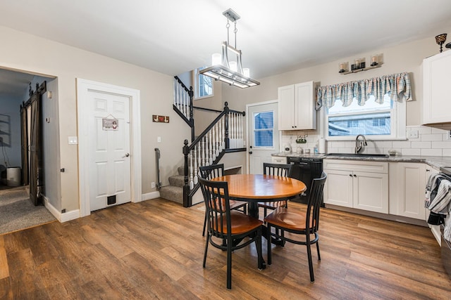 dining area featuring sink, a notable chandelier, and dark hardwood / wood-style floors