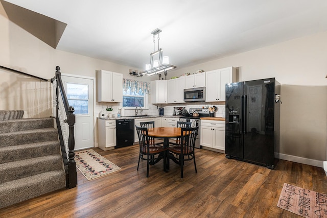 kitchen with pendant lighting, sink, black appliances, white cabinets, and decorative backsplash