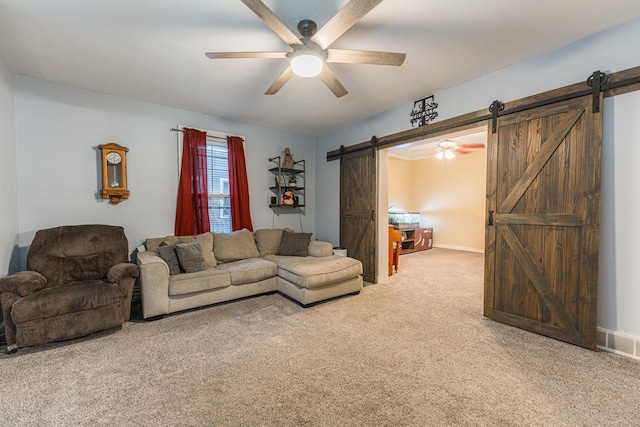 carpeted living room with a barn door and ceiling fan