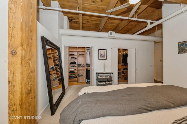 bedroom featuring multiple closets, light colored carpet, and wood ceiling