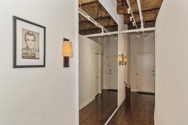 corridor featuring a towering ceiling and dark hardwood / wood-style floors