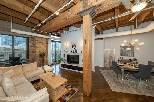 living room with beamed ceiling, rail lighting, dark wood-type flooring, and wooden ceiling