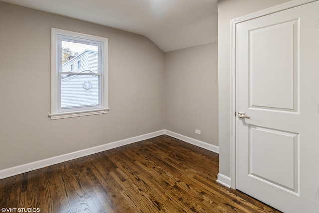 additional living space featuring vaulted ceiling and dark wood-type flooring