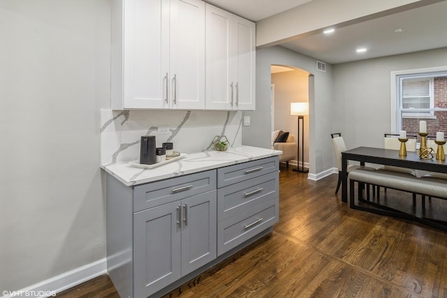 kitchen featuring dark hardwood / wood-style flooring, gray cabinets, and light stone countertops