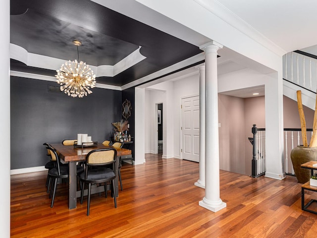 dining space with ornate columns, wood-type flooring, and crown molding