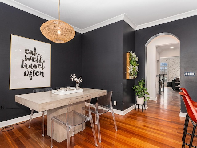 dining area with crown molding and hardwood / wood-style flooring