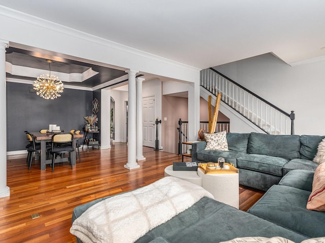 living room featuring hardwood / wood-style flooring, ornamental molding, and decorative columns