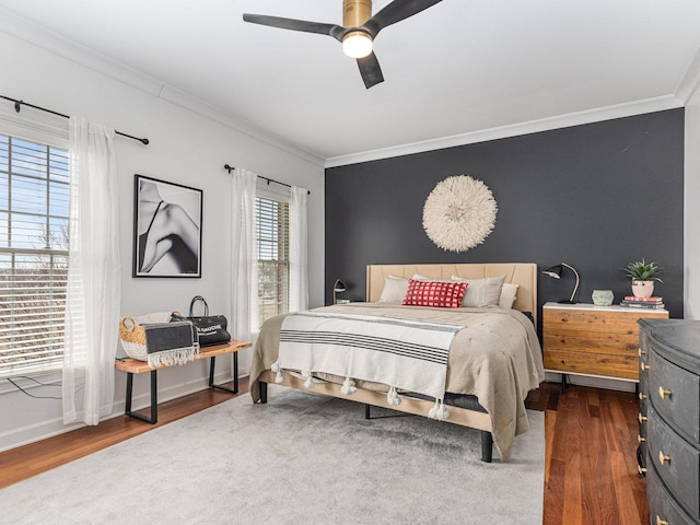 bedroom featuring crown molding, dark wood-type flooring, and ceiling fan