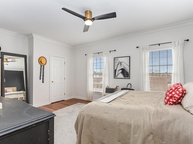 bedroom with crown molding, dark wood-type flooring, and ceiling fan