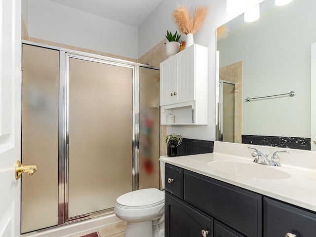 bathroom featuring vanity, toilet, tile patterned flooring, and a shower with door