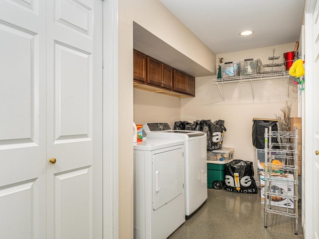 clothes washing area with cabinets and washing machine and clothes dryer