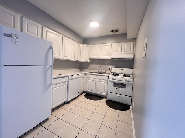 kitchen with sink, white appliances, light tile patterned floors, and white cabinets