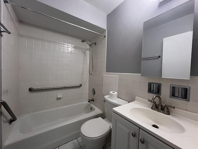 full bathroom featuring tiled shower / bath combo, vanity, tile walls, and toilet