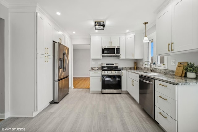 kitchen featuring sink, white cabinetry, decorative light fixtures, stainless steel appliances, and light stone countertops