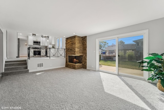 living room featuring a fireplace and carpet