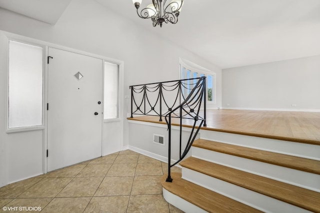 foyer featuring light tile patterned flooring and a notable chandelier