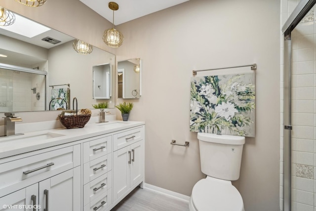 bathroom with vanity, an enclosed shower, and toilet