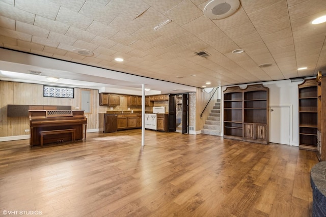 interior space with wood-type flooring and wooden walls