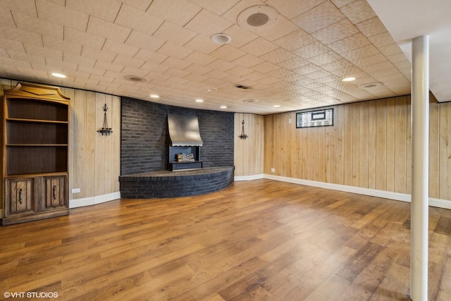 unfurnished living room with hardwood / wood-style floors and wood walls