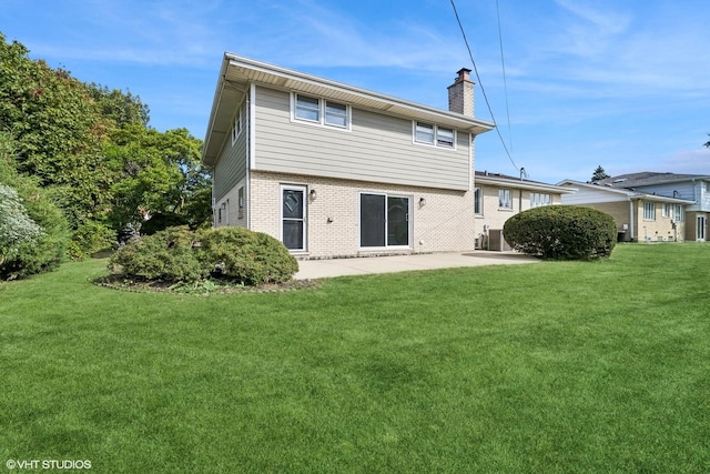 back of house with a patio and a lawn