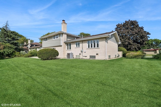 back of house featuring a lawn and central air condition unit