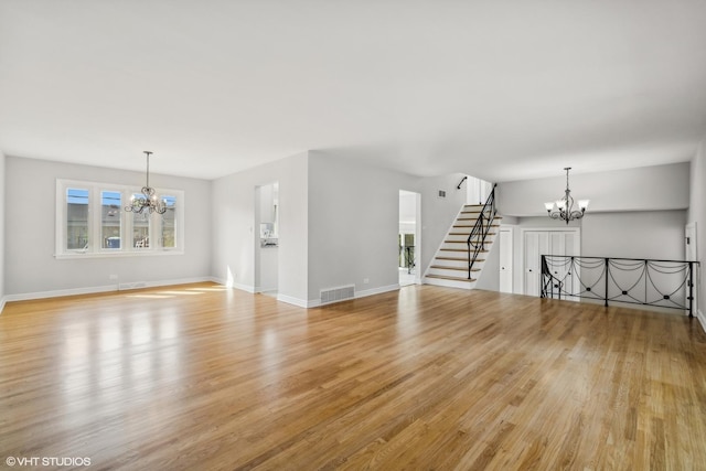 unfurnished living room with a chandelier and light hardwood / wood-style flooring