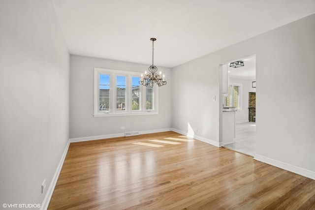 unfurnished dining area featuring hardwood / wood-style flooring and a chandelier