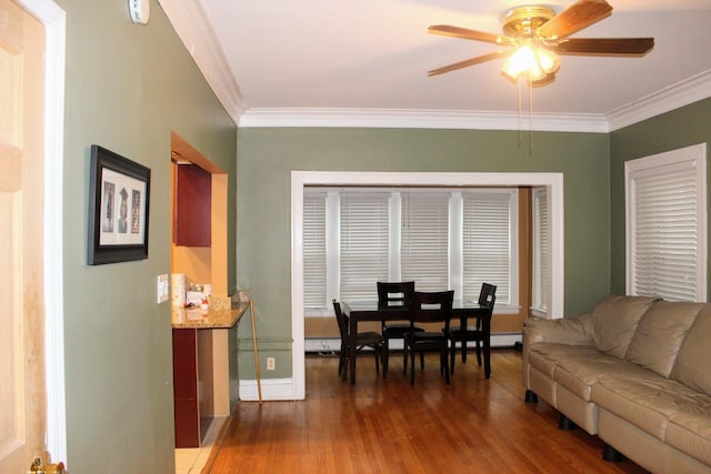 living room featuring ceiling fan, ornamental molding, and dark hardwood / wood-style flooring