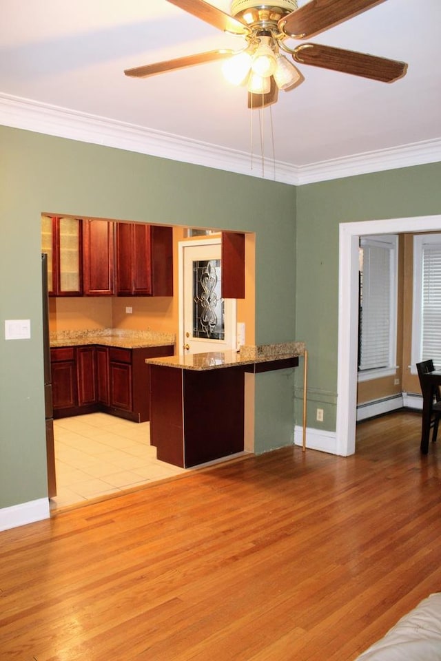 kitchen with a baseboard heating unit, crown molding, light hardwood / wood-style flooring, and kitchen peninsula