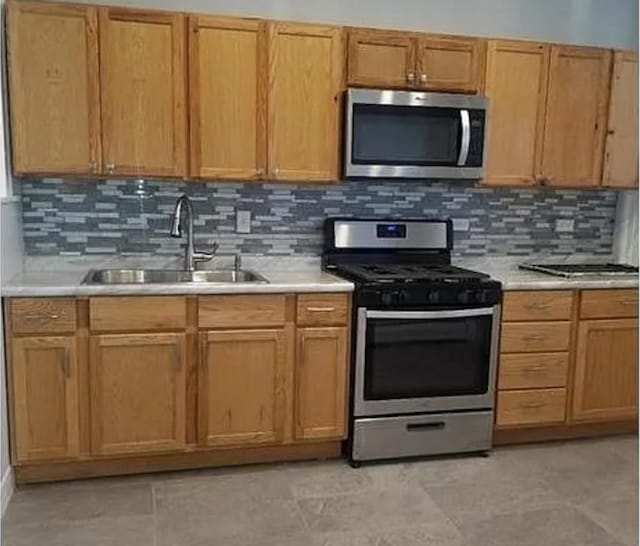 kitchen featuring appliances with stainless steel finishes, sink, and decorative backsplash