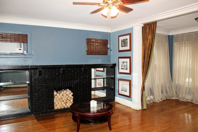 sitting room featuring crown molding, hardwood / wood-style flooring, a fireplace, and ceiling fan