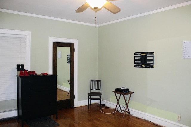 living area featuring a baseboard heating unit, crown molding, dark wood-type flooring, and ceiling fan