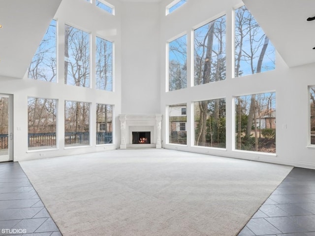 carpeted living room with a towering ceiling and plenty of natural light